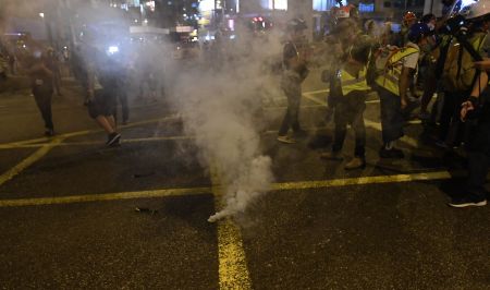 7月21日晚，一些示威者与警方在上环一带对峙。有数名示威者於对峙线內突然衝前向警方投掷攻击物后，迅速逃回示威人群当中。 警方当晚对非法占道聚集示威者清场。有示威者以自制烟雾弹投掷向警察方向。香港中通社图片